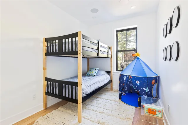 a bedroom with a bed and wooden floor