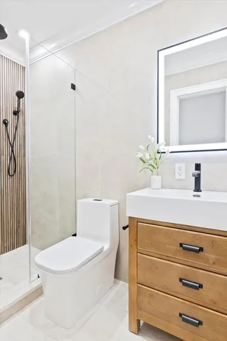 a bathroom with a sink a mirror a toilet and shower