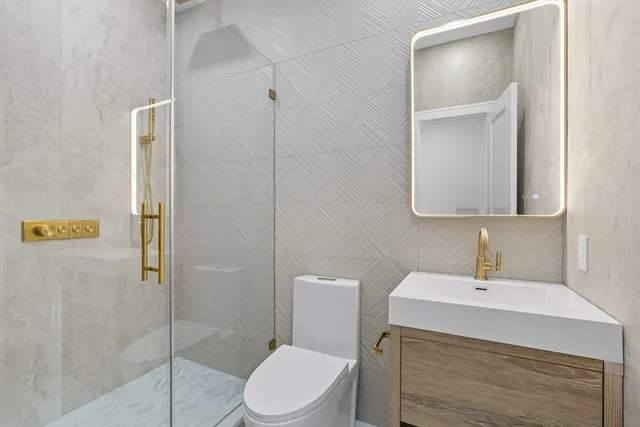 a bathroom with a granite countertop sink a toilet and shower
