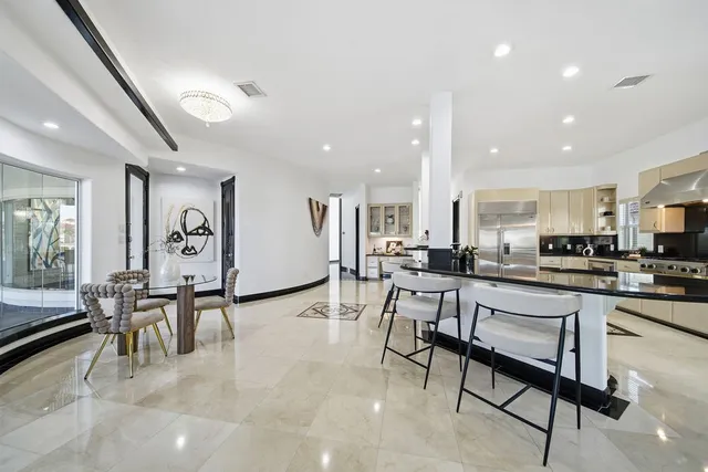 a large kitchen with a large counter top stainless steel appliances and cabinets