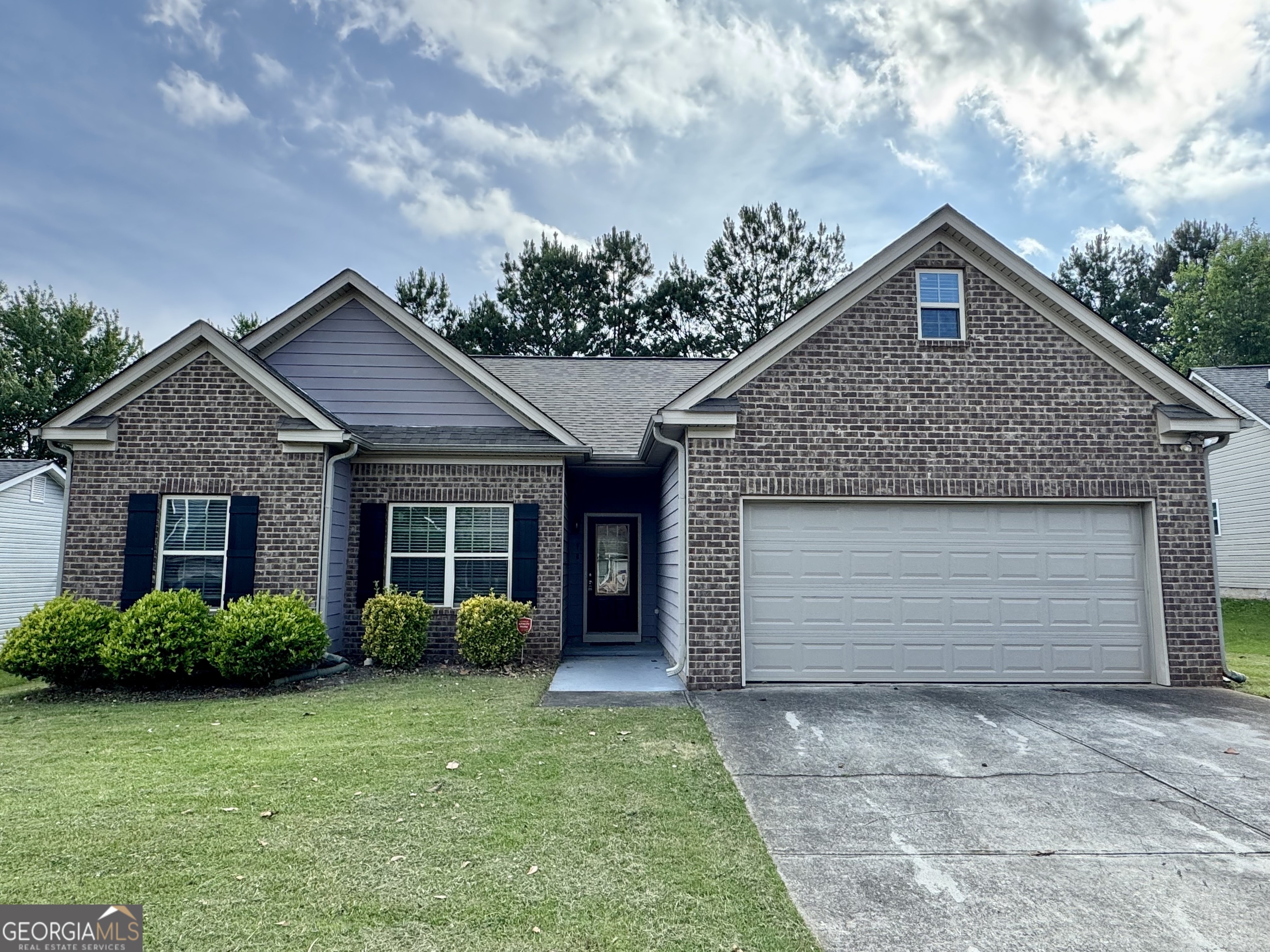 a front view of a house with a garden and plants