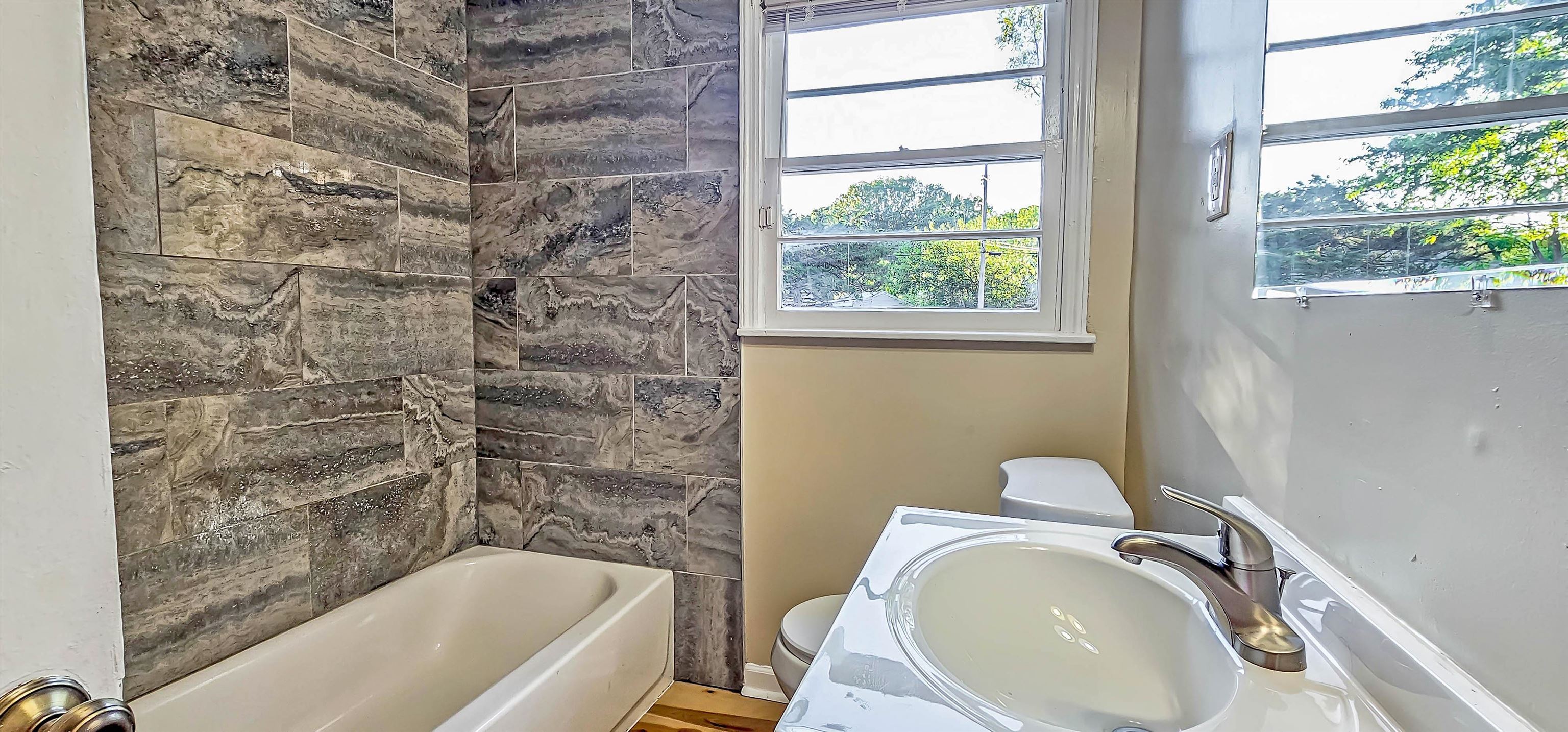 4420 Helene Road Memphis, TN 38117 - Photo 4 of 22 a bathroom with a granite countertop sink toilet and bathtub