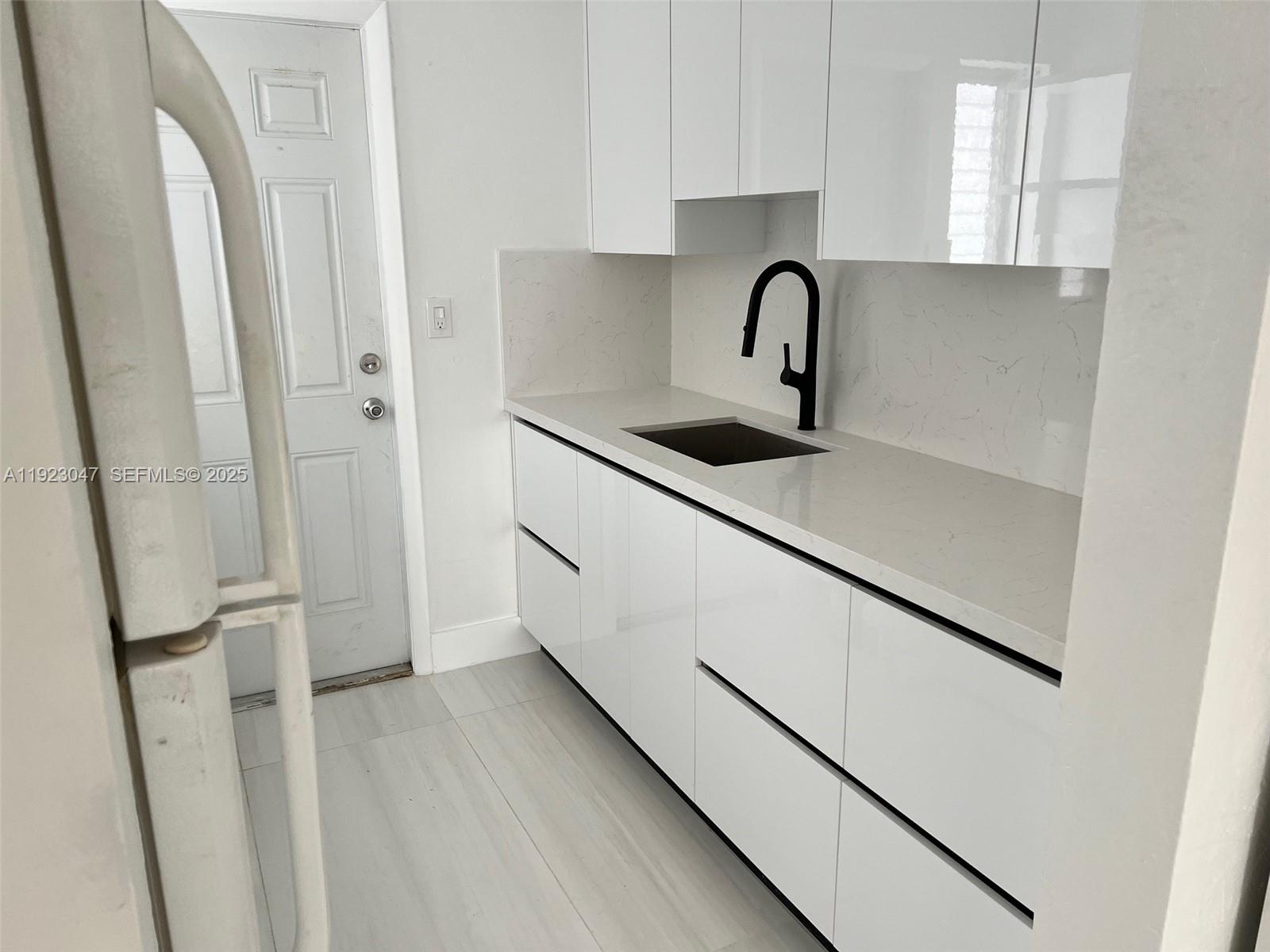 944 Meridian Avenue, Unit 10 Miami Beach, FL 33139 - Photo 11 of 15 a kitchen with stainless steel appliances granite countertop a sink stove and refrigerator