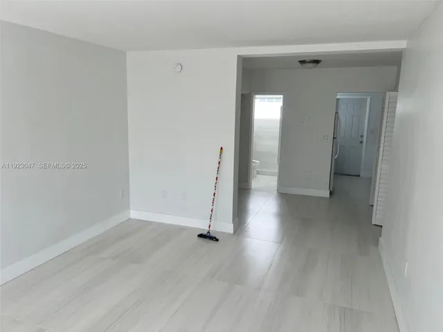 an empty room with wooden floor and a mirror