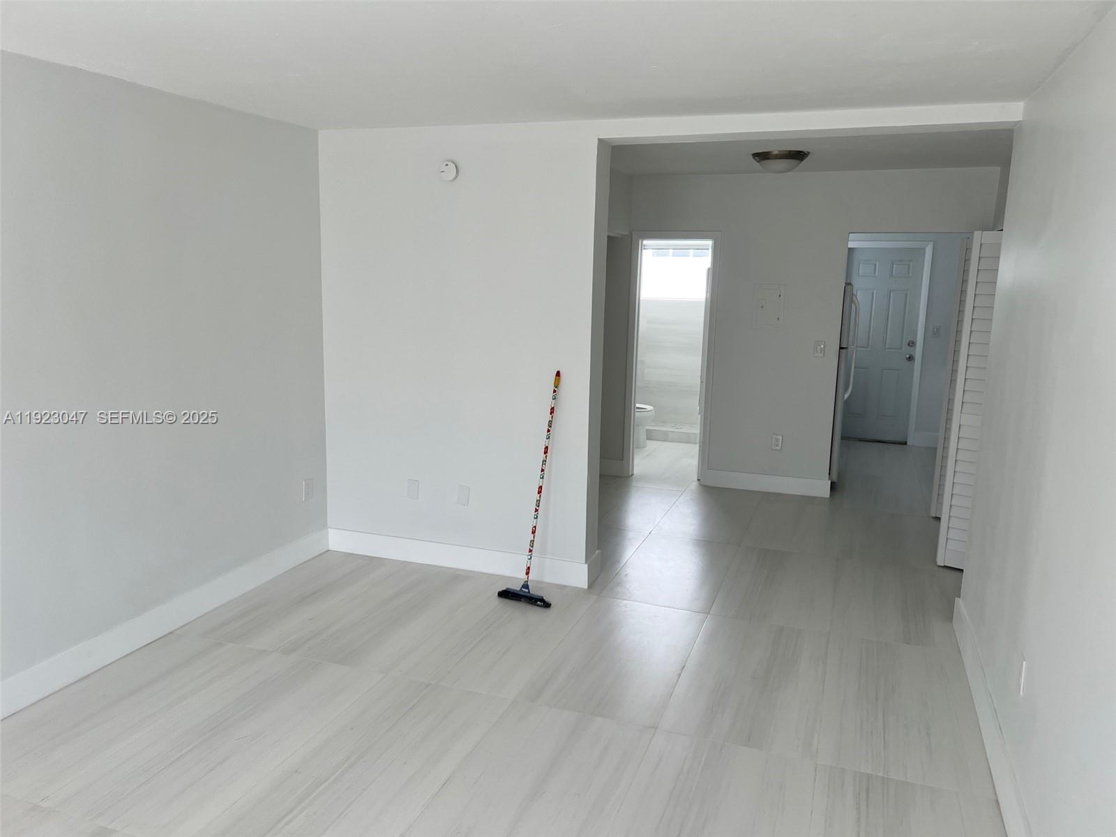 944 Meridian Avenue, Unit 10 Miami Beach, FL 33139 - Photo 2 of 15 an empty room with wooden floor and a mirror