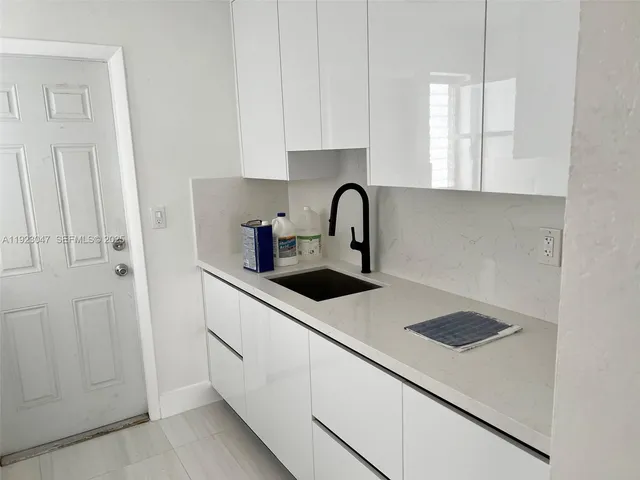 a kitchen with a sink and white cabinets