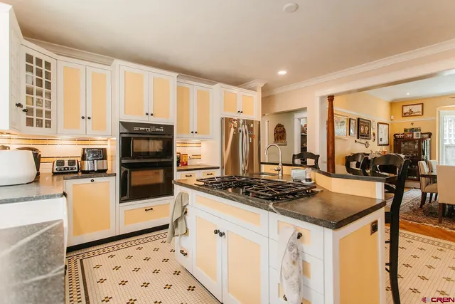 a kitchen with stainless steel appliances a stove a sink a microwave a refrigerator and cabinets