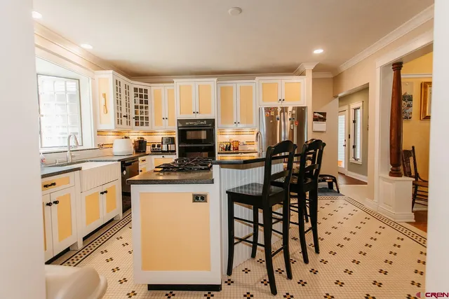 a kitchen with stainless steel appliances granite countertop a stove a sink a dining table and chairs