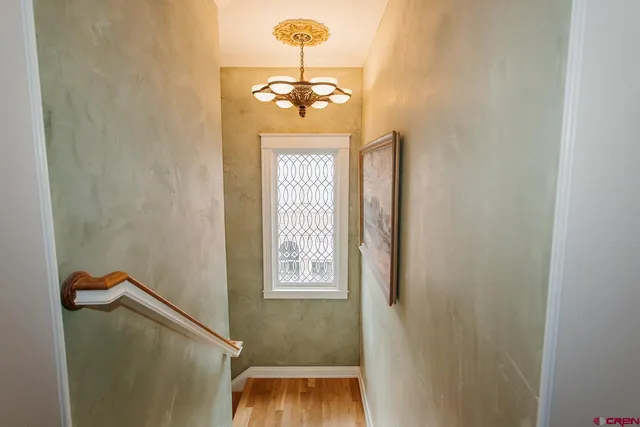a view of hallway with windows and wooden floor