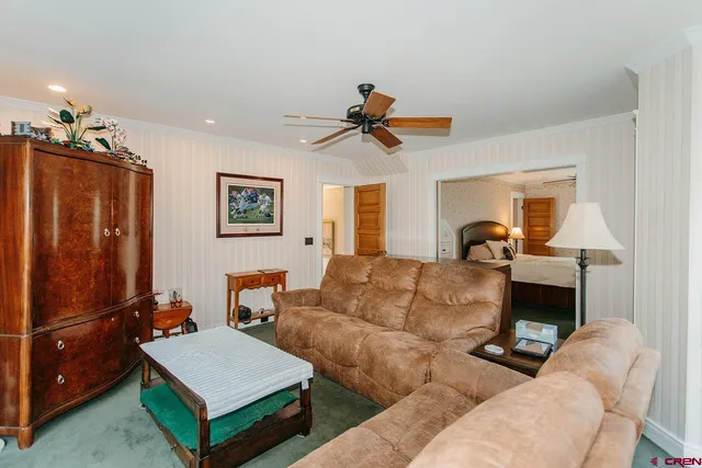 a living room with furniture a flat screen tv and a lamp