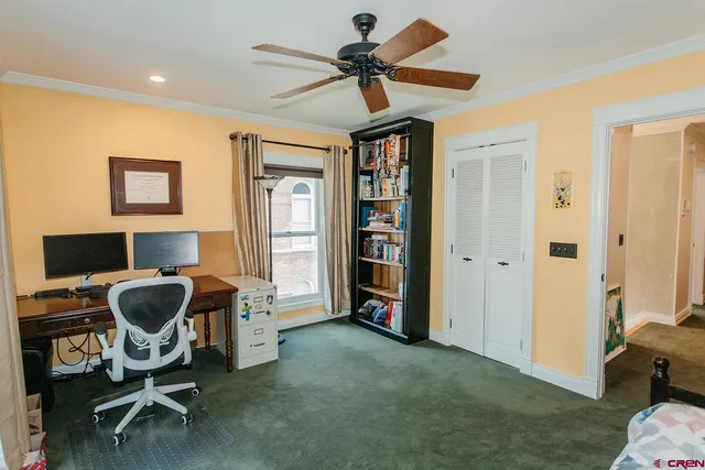 a view of a workspace with furniture and a window