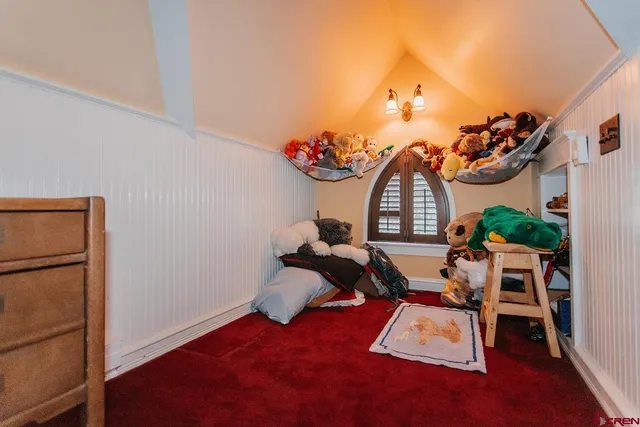 a view of a room with gym equipment and wooden floor