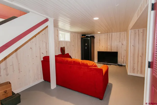 a living room with furniture and a bookshelf with wooden floor