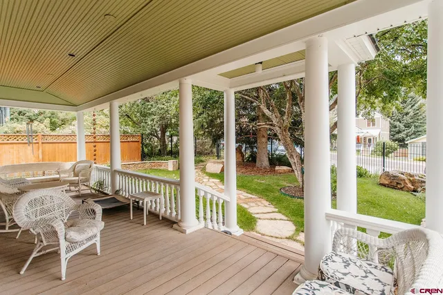 a balcony with chairs and wooden floor