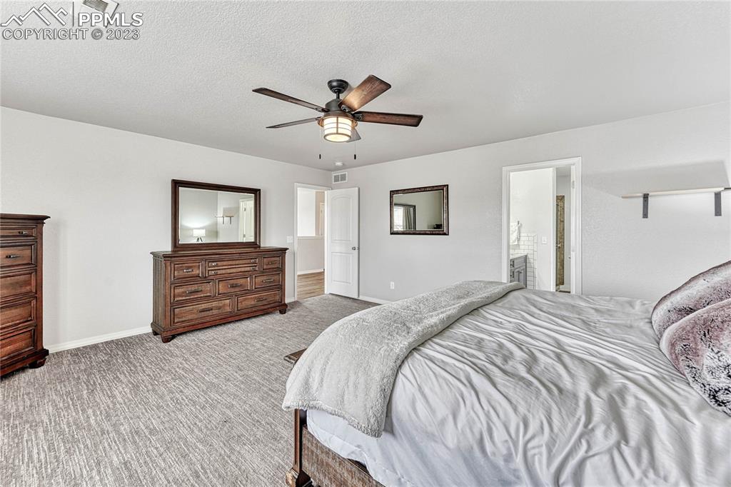 1064 Diamond Rim Drive Colorado Springs, CO 80921 - Photo 14 of 30 a bed room with a bed and a chandelier