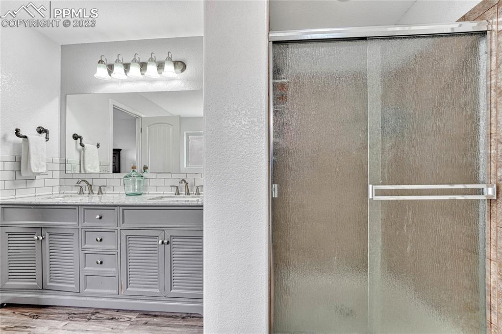 1064 Diamond Rim Drive Colorado Springs, CO 80921 - Photo 17 of 30 a bathroom with a granite countertop sink a shower and a mirror