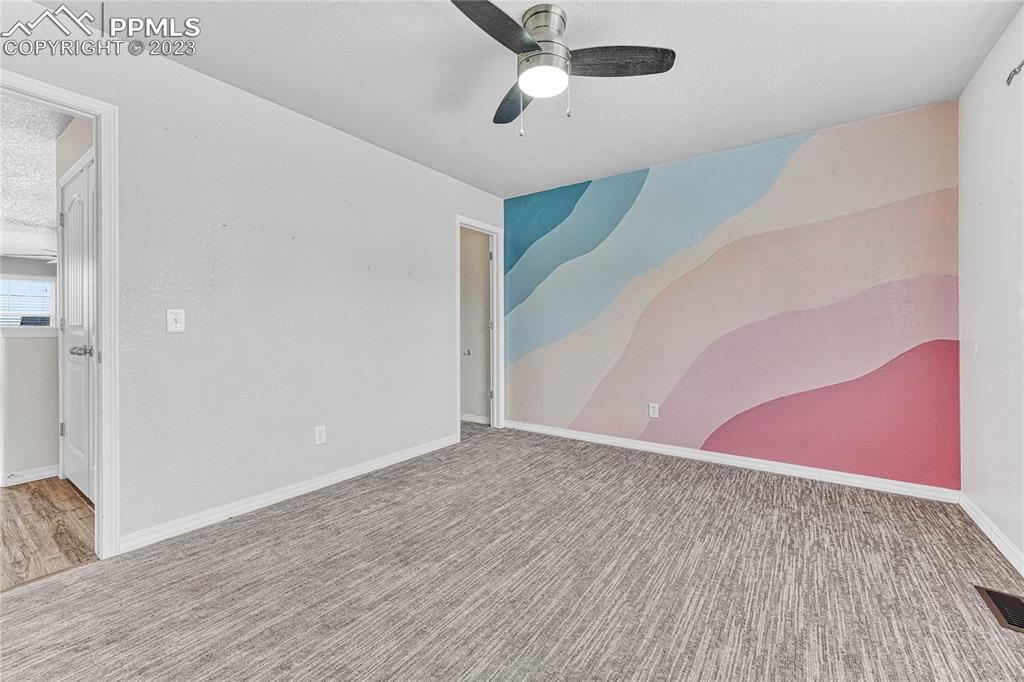 1064 Diamond Rim Drive Colorado Springs, CO 80921 - Photo 22 of 30 an empty room with wooden floor fan and windows