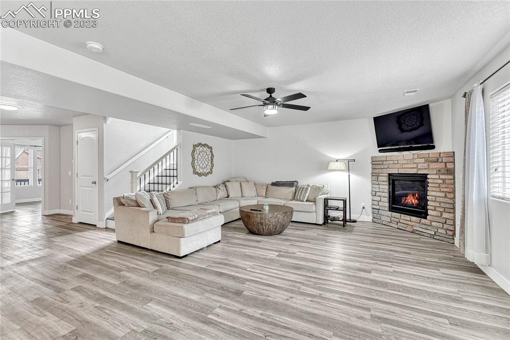 1064 Diamond Rim Drive Colorado Springs, CO 80921 - Photo 6 of 30 a living room with furniture a fireplace and a flat screen tv
