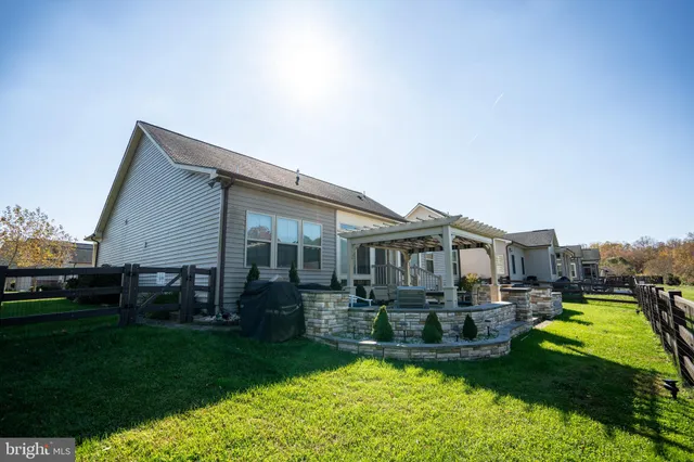 a view of a house with a big yard plants and large trees