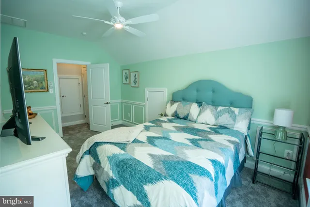 a bedroom with a bed mirror and a desk