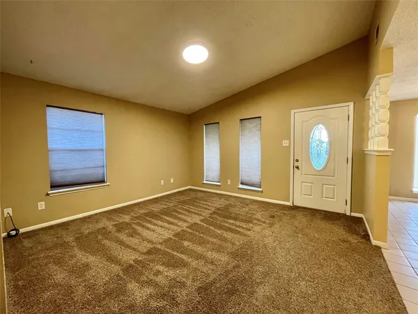 a view of an empty room with window and bathroom
