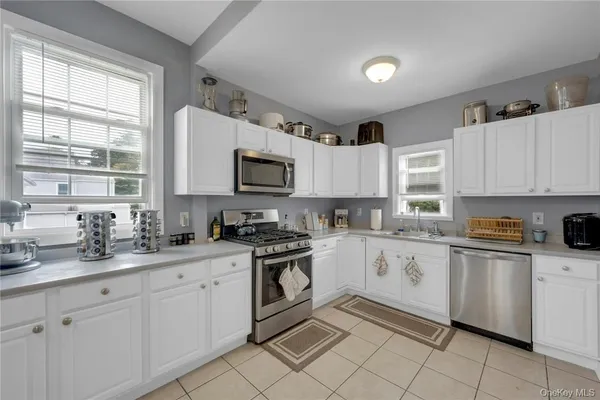 a kitchen with white cabinets appliances and a sink
