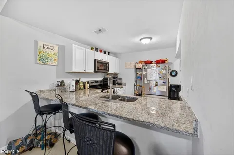 a view of a kitchen with granite countertop cabinets table and chairs