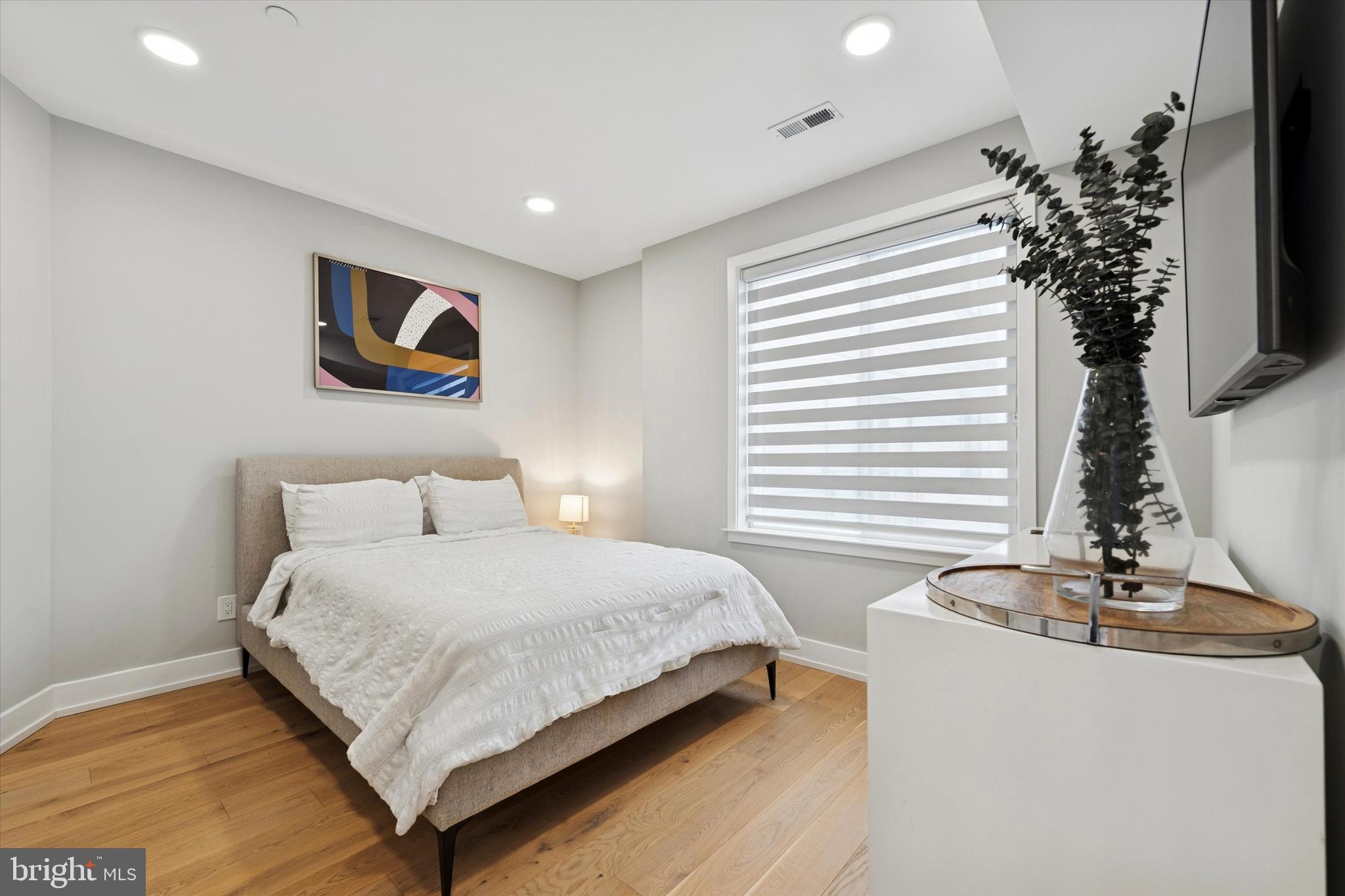 700 Moyer Street, Unit 210 Philadelphia, PA 19125 - Photo 9 of 14 a bedroom with a bed and a potted plant