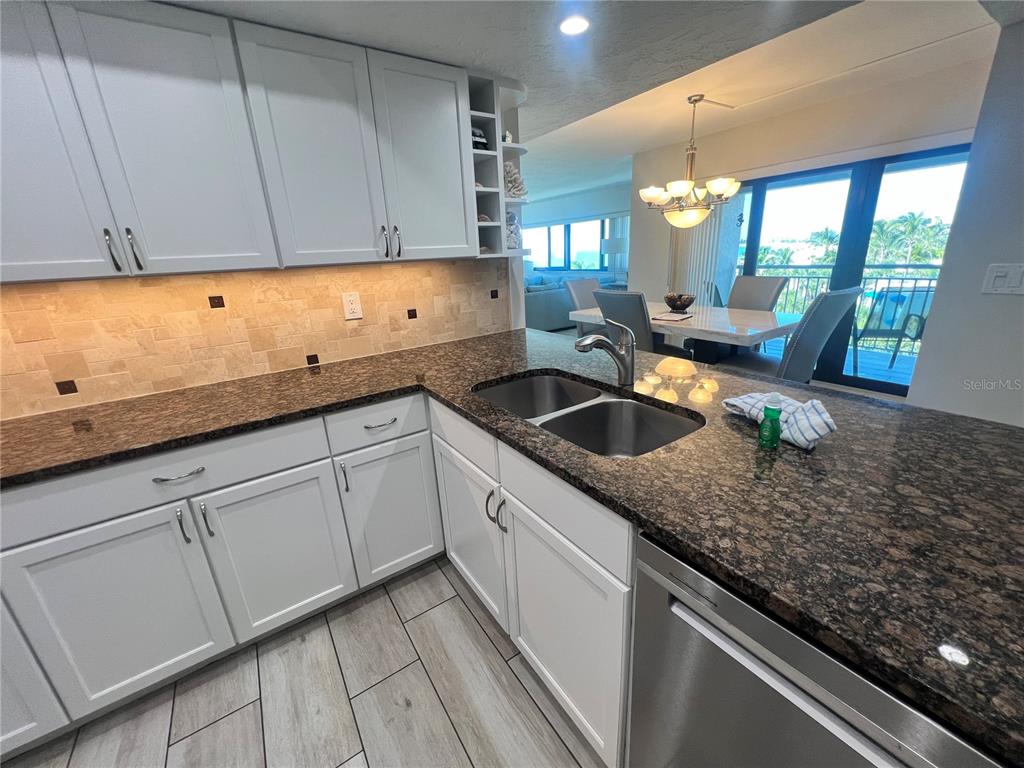 1001 Point Of Rocks Road, Unit 512 Sarasota, FL 34242 - Photo 13 of 44 a kitchen with granite countertop a sink and white cabinets