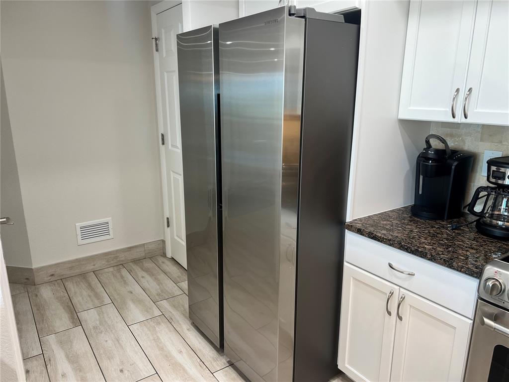 1001 Point Of Rocks Road, Unit 512 Sarasota, FL 34242 - Photo 15 of 44 a kitchen with a refrigerator and cabinets