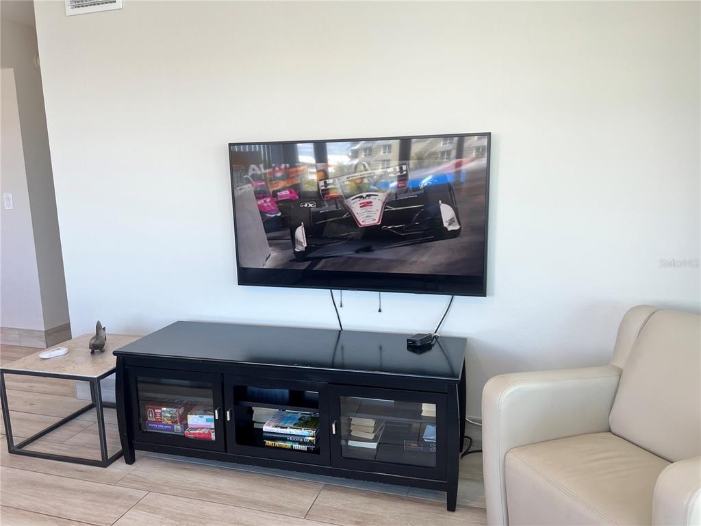 1001 Point Of Rocks Road, Unit 512 Sarasota, FL 34242 - Photo 19 of 44 a living room with furniture a flat screen tv and a wall
