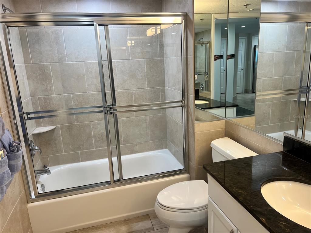 1001 Point Of Rocks Road, Unit 512 Sarasota, FL 34242 - Photo 6 of 44 a bathroom with a granite countertop sink toilet and shower