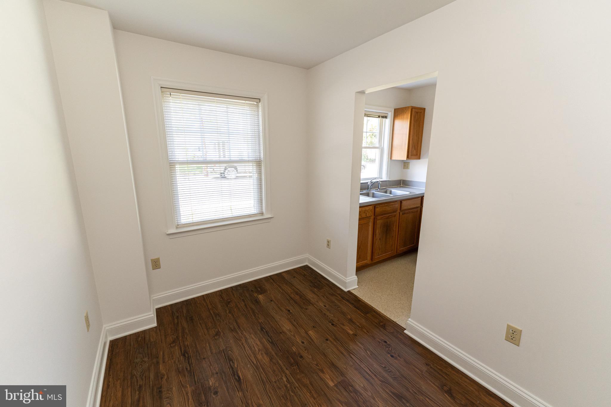 804 Travers Street, Unit 2 Cambridge, MD 21613 - Photo 8 of 26 an empty room with wooden floor and windows