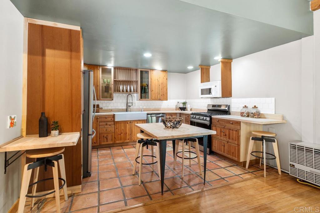455 Cole Ranch Road Encinitas, CA 92024 - Photo 32 of 43 a kitchen with stainless steel appliances kitchen island granite countertop a sink and cabinets