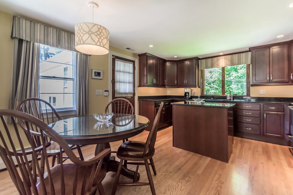 208 Haggetts Pond Road Andover, MA 01810 - Photo 3 of 23 a kitchen with granite countertop a stove a sink dishwasher a dining table and chair with wooden floor