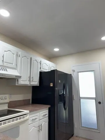 a kitchen with stainless steel appliances granite countertop a refrigerator and a stove