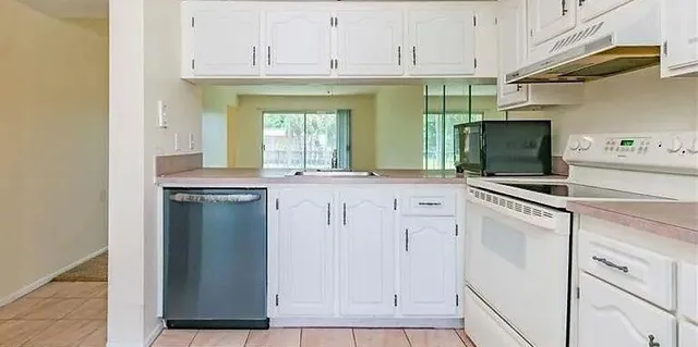 a kitchen with white cabinets and white appliances