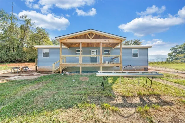 a view of a house with backyard and sitting area