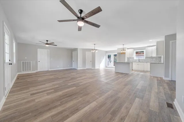 a view of a kitchen with wooden floor and a ceiling fan