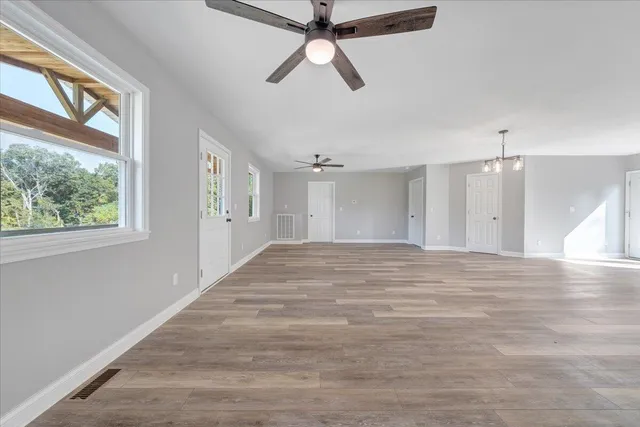 a view of empty room with window and ceiling fan