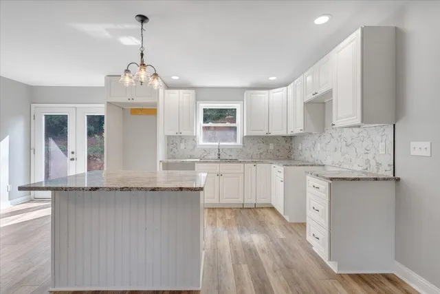 a kitchen that has a lot of cabinets and wooden floor