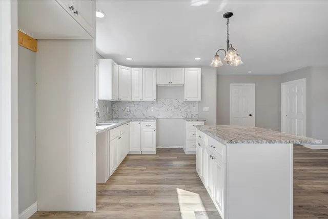 a large kitchen with granite countertop stainless steel appliances lots of counter space sink and cabinets