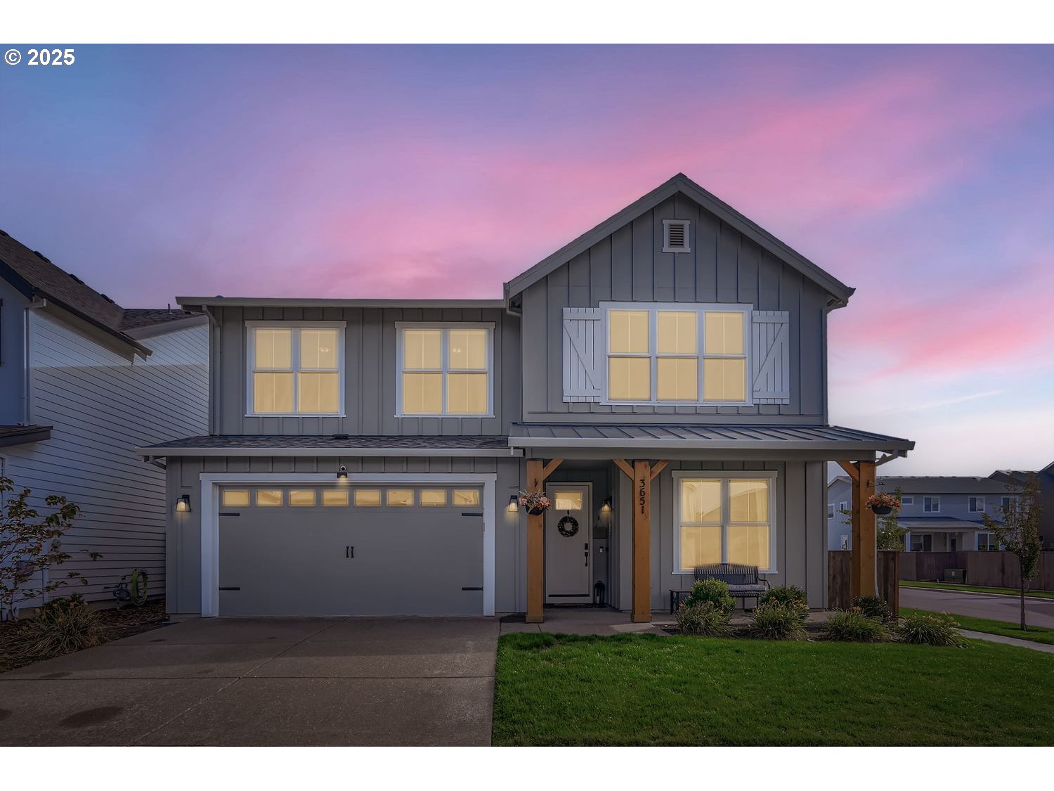 a front view of a house with a yard and potted plants
