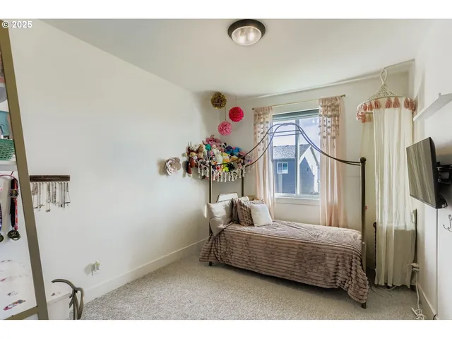 a bedroom with furniture and a flat screen tv