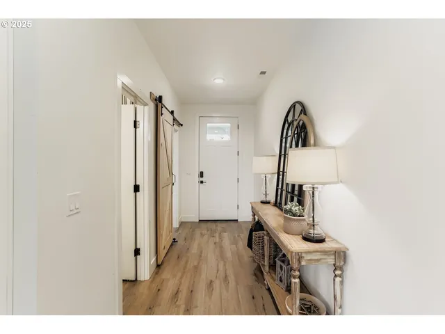 a view of hallway with furniture and wooden floor