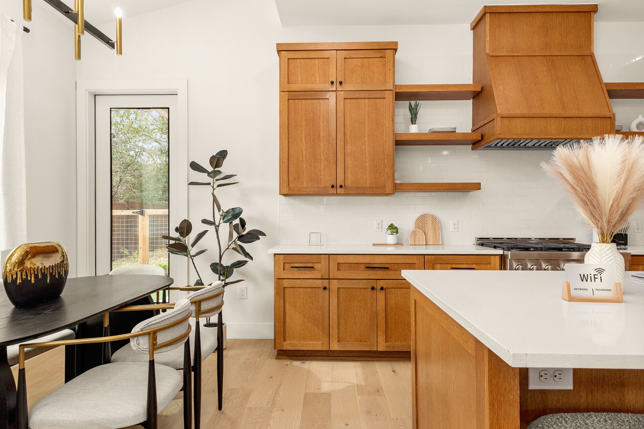 4418 Red River Street, Unit 1 Austin, TX 78751 - Photo 14 of 40 Kitchen featuring open shelves, light wood-style floors, tasteful backsplash, wood finish cabinets, and stainless steel gas stove