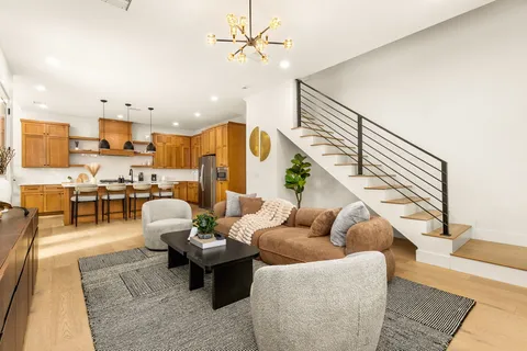 a living room with furniture kitchen view and a rug