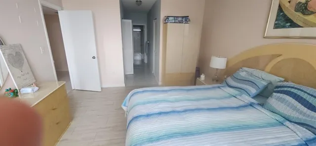 a bedroom with a bed and a flat tv screen on a dresser