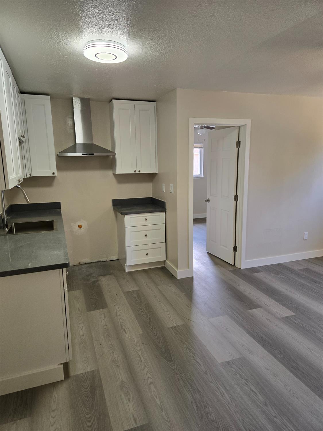 1036 North Sutter Street, Unit 5 Stockton, CA 95202 - Photo 2 of 10 a kitchen with cabinets and wooden floor