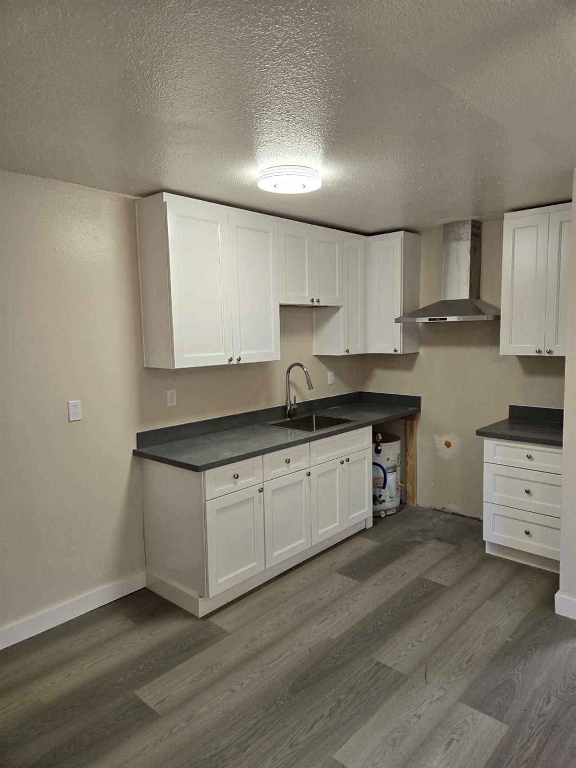 1036 North Sutter Street, Unit 5 Stockton, CA 95202 - Photo 3 of 10 a kitchen with granite countertop a sink cabinets and stainless steel appliances